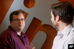 FILE - LinkedIn co-founder Reid Hoffman, left, sits with CEO Jeff Weiner in the lobby of LinkedIn's Mountain View, Calif., headquarters on Tuesday, May 7, 2013. (AP Photo/Noah Berger)