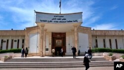 FILE - People walk outside Iraqi Criminal Court in Baghdad's Karkh district, Iraq, May 5. 
