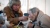People have a meal after arriving from the Ukrainian city of Mariupol at a center for displaced people in Zaporizhzhia, Ukraine, May 3, 2022. 