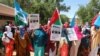 Somali women chant slogans and hold placards as they protest against Somali Islamist group Al-Shabaab at General Kahiye Police Academy in Mogadishu on Jan. 2, 2020. 