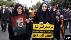 তেহরানে শুক্রবারের জুম্মার নামাজের আগে ফিলিস্তিনপন্থী মিছিলে যোগ দেয় ইরানিরা। এদের একজনের হাতে ইসরাইল-বিরোধী প্ল্যাকার্ড। ১৩ অক্টোবর, ২০২৩।