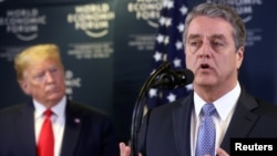 FILE - Director-General of World Trade Organization Roberto Azevedo speaks next to U.S. President Donald Trump during a news conference at the 50th World Economic Forum in Davos, Switzerland, Jan. 22, 2020.