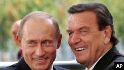 File--- Then-German Chancellor Gerhard Schroeder, right, welcoming Russia's President Vladimir Putin in Berlin, Germany, Sept. 8, 2005. 