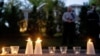 Police look on as candles left by pro-choice demonstrators sit outside the house of Supreme Court Justice Samuel Alito in Alexandria, Virginia, on May 9, 2022.