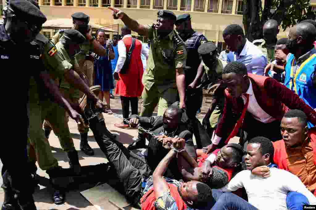 Ugandan police officers detain students marching towards parliament to protest against steep rise in the cost of commodities, in Kampala, May 5, 2022. 