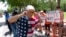 A member of the National Rifle Association plugs his ears with his fingers as he walks past protesters during the NRA's annual meeting at the George R. Brown Convention Center in Houston, May 27, 2022.