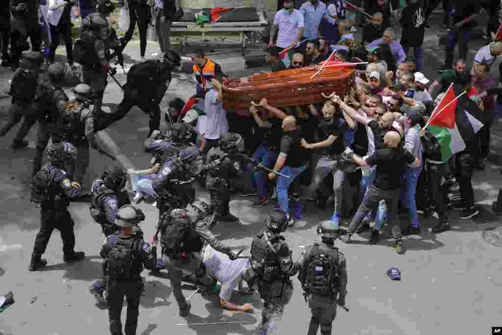 Israeli police confront mourners as they carry the casket of slain Al Jazeera veteran journalist Shireen Abu Akleh during her funeral in east Jerusalem, May 13, 2022.&nbsp;Abu Akleh, a Palestinian-American reporter who covered the Mideast conflict for more than 25 years, was shot dead during an Israeli military raid in the West Bank town of Jenin.