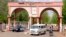 A man rides a motorbike taxi past police vehicles at the entrance of Shehu Shagari College of Education in Sokoto, Nigeria, May 13, 2022. Deborah Yakubu, who was killed May 12 over allegedly blasphemous statements, was a student at the school.