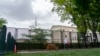 A pedestrian and their dog walk past fencing that blocks off the area around the U.S. Supreme Court Sunday, May 8, 2022, in Washington.