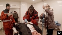 被称为泰拉的尤利娅·派耶夫斯卡和急救人员在乌克兰马里乌波尔帮助一名受伤人员。(2022年3月6日)