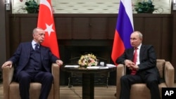 FILE - In this Sept. 29, 2021, file photo, Russian President Vladimir Putin, right, and Turkish President Recep Tayyip Erdogan talk during their meeting in the Bocharov Ruchei residence in the Black Sea resort of Sochi, Russia.