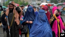 阿富汗妇女在塔利班看守下在首都喀布尔的一个市场上行走（2022年5月3日）