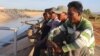 Farmers watch over an irrigation canal and as they wait to demand authorities pump more water into the irrigation system in Pursat province’s Bakan district, December 18, 2019 (Sun Narin/VOA Khmer) 