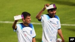 FILE - Two men pose with England vs. Iran match tickets, produced by HID, during a community event at Al Wakrah Stadium on November 17, 2022 in Doha, Qatar. 