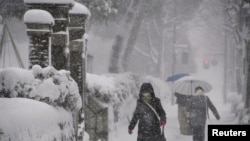 Warga berjalan di tengah hujan salju di Kanazawa, Prefektur Ishikawa, Jepang tengah, 23 Desember 2022. (Kyodo/via REUTERS)