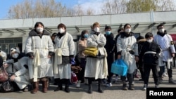 资料照：上海一家火葬场外身穿孝服的亲属为离世的亲人送行。（2023年1月4日）