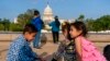 FILE - The Safi family celebrates Eid by taking family photographs on the National Mall, May 3, 2022, near the US Capitol in Washington. The family was evacuated from Afghanistan and is trying to make a new life in the US.