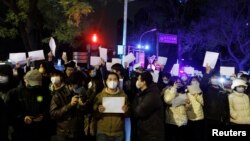 2022年11月28日，在中国北京，随着新冠肺炎疫情的持续，人们在为乌鲁木齐火灾遇难者守夜后，手持白纸抗议新冠肺炎疫情限制措施。