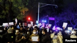 2022年11月28日，在中国北京，随着新冠肺炎疫情的持续，人们在为乌鲁木齐火灾遇难者守夜后，手持白纸抗议新冠肺炎疫情限制措施。