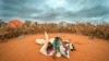 FILE - A Somali woman and child wait to be given a spot to settle at a camp for displaced people amid a drought on the outskirts of Dollow, Somalia on Sept. 20, 2022. 