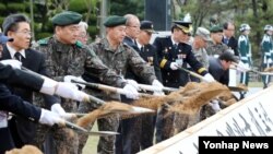 18일 한국 경북 칠곡군 다부동전적기념관에서 열린 2014년도 6·25 전사자 유해발굴 개토식에서 참석자들이 첫 삽을 뜨고 있다.