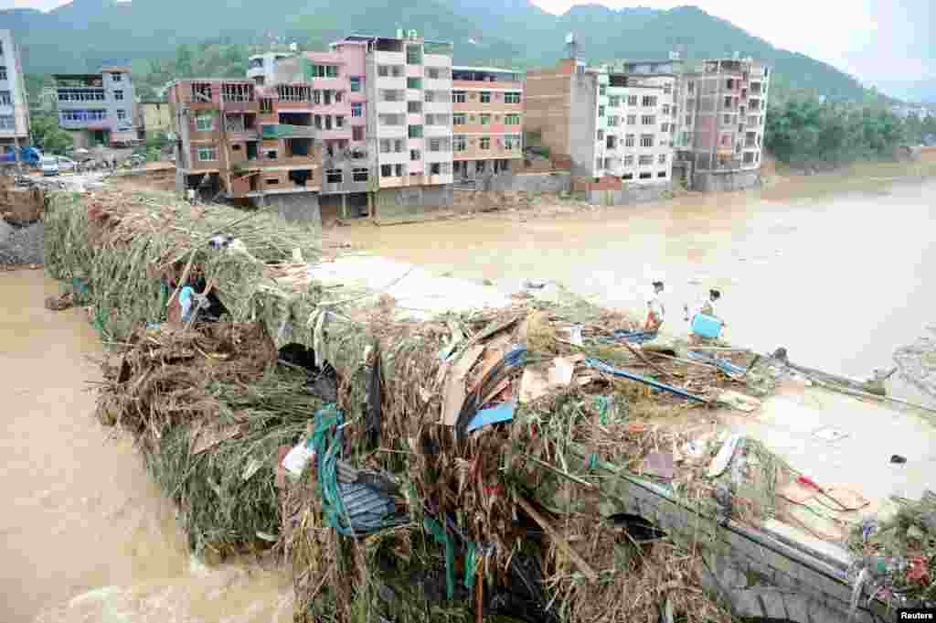 Warga berjalan di jembatan pasca bencana topan Nepartak melanda Fuzhou, Fujian, China.