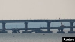 资料照片：视图显示刻赤海峡中因爆炸而受损的克里米亚大桥的一部分。（2022年10月17日）