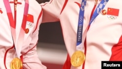 中国场地自行车女子团体赛两名金牌得主在东京奥运会领奖台上违反奥林匹克宪章，佩戴中共前领导人毛泽东的像章。（2021年8月2日）