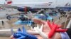 An Airbus employee presents three model airplanes in blue, white and red, made from starch using a 3D printing technique during the opening of 50th Paris Air Show, at the Le Bourget airport near Paris, June 17, 2013. In the future the company hopes to use