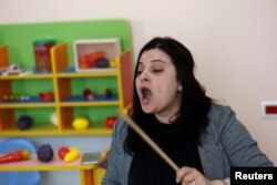 Halimeh Sarabtah, yang lahir tuli, menggunakan terapi musik sebagai pengobatan psikologis untuk anak-anak cacat di Ramallah, Tepi Barat yang diduduki Israel, 5 April 2022. (REUTERS/Mohamad Torokman)