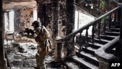 Un soldat russe patrouille au théâtre de Marioupol qui a été bombardé le 16 mars dernier alors que les troupes russes intensifient une campagne pour prendre cette ville portuaire stratégique, le 12 avril 2022.