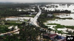 Jalan raya dan rumah-rumah yang terendam air banjir di kota Abuyog, provinsi Leyte, Filipina selatan, 11 April 2022, setelah hujan lebat yang dipicu oleh badai tropis Agaton. (Foto oleh Bobbie ALOTA / AFP)