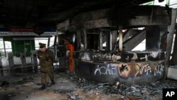 A police officer walks in a subway station that was torched during protests, in Santiago, Chile, Oct. 19, 2019. The protests began Friday afternoon when high school students flooded subway stations, dodging fares and vandalizing stations over a fare hike.