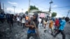 FILE - A protester carries a piece of wood simulating a weapon during a protest demanding the resignation of Prime Minister Ariel Henry, in the Petion-Ville area of Port-au-Prince, Haiti, Oct. 3, 2022.