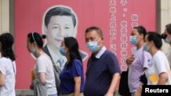 上海民众走过街头树立的一面中国领导人习近平的宣传画。（2022年8月31日）