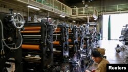 ແຟ້ມຮູບ-ພະນັກງານຄົນນຶ່ງ ກໍາລັງກວດເບິ່ງເຄື່ອງຈັກ ຢູ່ທີ່ໂຮງງານ ຮິກາຊິໂອຊາກາ (Higashiosaka), ຍີ່ປຸ່ນ, ວັນທີ 23 ມິຖຸນາ 2022. 