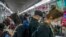 Commuters wearing face masks ride a subway train in Beijing, April 12, 2022. The U.S. has ordered all nonemergency consular staff to leave Shanghai, which is under a tight lockdown to contain a COVID-19 surge.