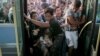 Refugees and migrants push each other as they try to board a bus following their arrival onboard the Eleftherios Venizelos passenger ship at the port of Piraeus, near Athens, Greece, Sept. 7, 2015.