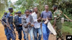 ARCHIVES - Trois hommes menottés sont emmenés par la police à Jenda, Burundi, le 12 juin 2015.