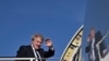 Britain's Prime Minister Boris Johnson waves as he boards a plane at Stansted Airport, northeast of London, April 20, 2022, for a visit to India. 