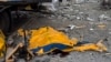 The body of a man is covered by a tarp from a damaged truck following a Russian bombing of a factory in Kramatorsk, in eastern Ukraine, Apr. 19, 2022. 