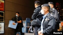 资料照：2021年12月29日，香港一名警察在搜查了《立场新闻》办公室后收集了一箱证据。（路透社）