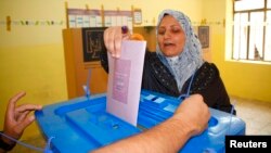 A woman casts her vote at a ballot box during the Iraq's provincial elections at a polling station in Mosul, 390 km (242 miles) north of Baghdad, June 20, 2013.