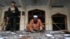 A rescue worker collects evidence from the site of an explosion in a Shi'ite mosque in Peshawar, Pakistan, Feb. 13, 2015. 