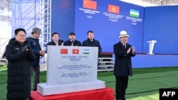 2024年12月27日，吉尔吉斯斯坦总统萨德尔·贾帕罗夫(右)、中国国家发展改革委主任郑栅洁(左)等官员出席中吉乌铁路开工。(吉尔吉斯斯坦总统办公室提供／法新社发布)