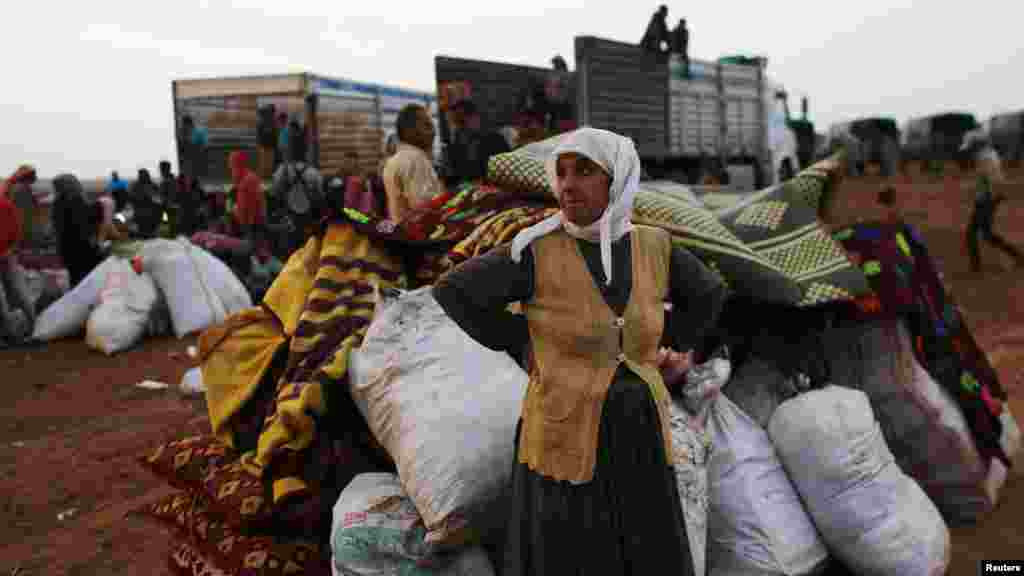 Comme des milliers d&rsquo;autres réfugiés qui traversent la frontière syrienne pour la Turquie, cette femme attend un moyen de transport dans la ville de Kobani. (le 2 octobre)&nbsp; 