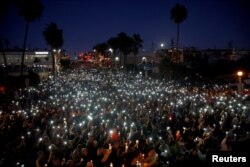 美国加州曼哈顿海滩市的人们悼念在拉斯维加斯城 “91号公路丰收节” 美国乡村音乐会上遭到枪击的遇难者、该市居民拉希尔·帕克和桑迪·凯西（2017年10月4日）。