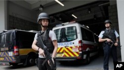 当英籍银行业者鲁里克·贾廷乘坐的警车抵达香港最高法院时警察持枪看守。（2017年12月12日）