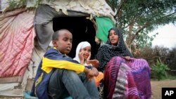 Ubah Mohamed Abdullahi, 33, right, sits with her son Abdullahi Yusuf Ahmed, 8, left, and daughter Neshad Yusuf Ahmed, 5, outside her hut in the Shedder refugee camp in far eastern Ethiopia. 