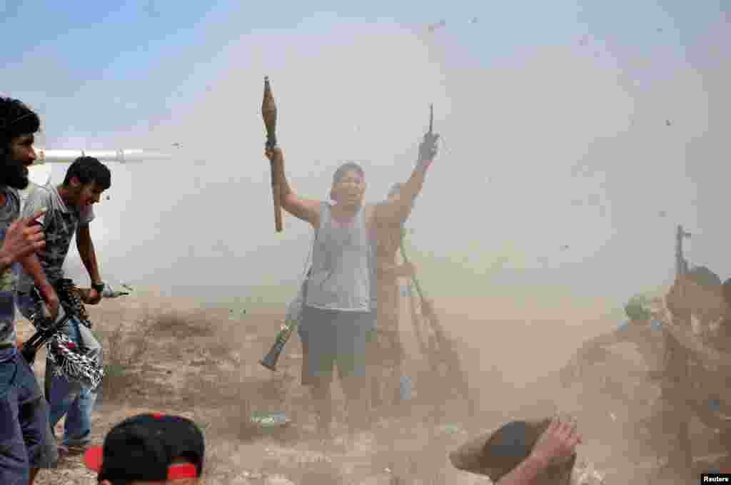 A fighter of Libyan forces allied with the U.N.-backed government gestures after other fighters fire artillery at Islamic State fighters during a battle in Sirte, Libya.
